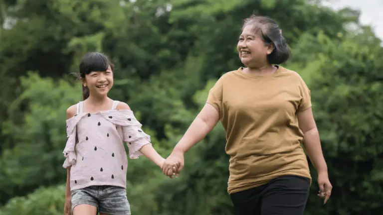 grandmother and granddaughter walking in park